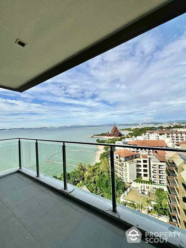 Stunning ocean view from a high-rise balcony overlooking the coastline and cityscape.