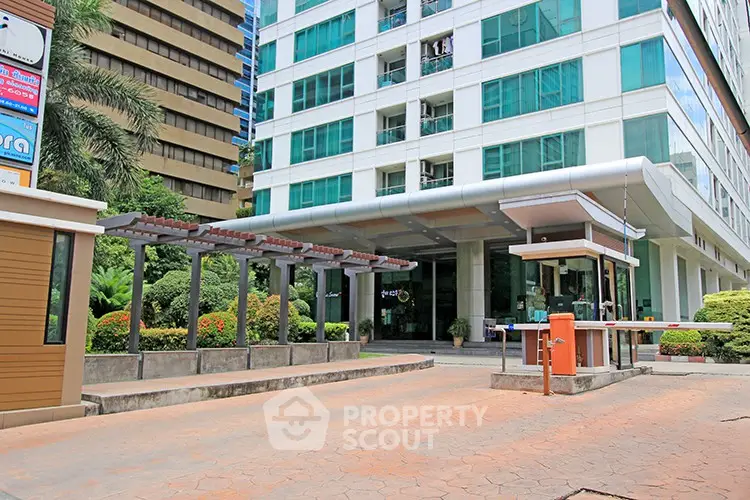 Modern building entrance with lush landscaping and security gate