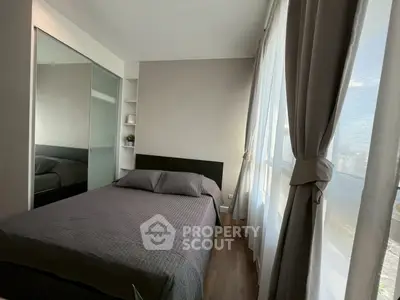 Modern bedroom with large windows and sleek design, featuring a comfortable bed and stylish decor.