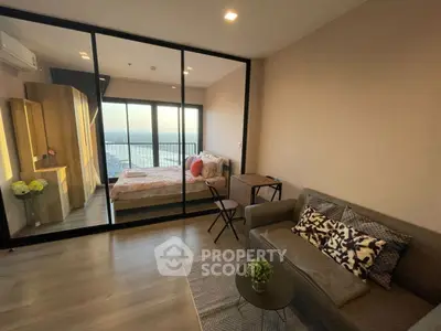Modern apartment with glass partition, cozy living area, and stunning city view.