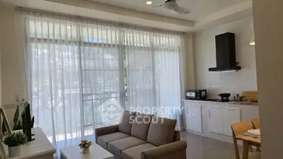 Modern living room with open kitchen and large windows, featuring cozy seating and contemporary decor.