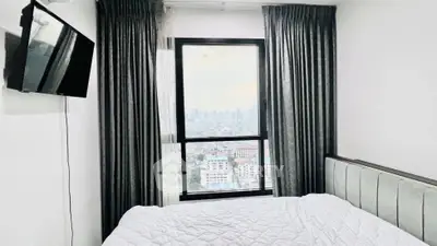 Modern bedroom with city view and wall-mounted TV