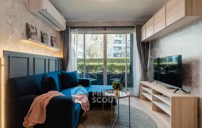 Stylish living room with modern decor and balcony view in urban apartment.
