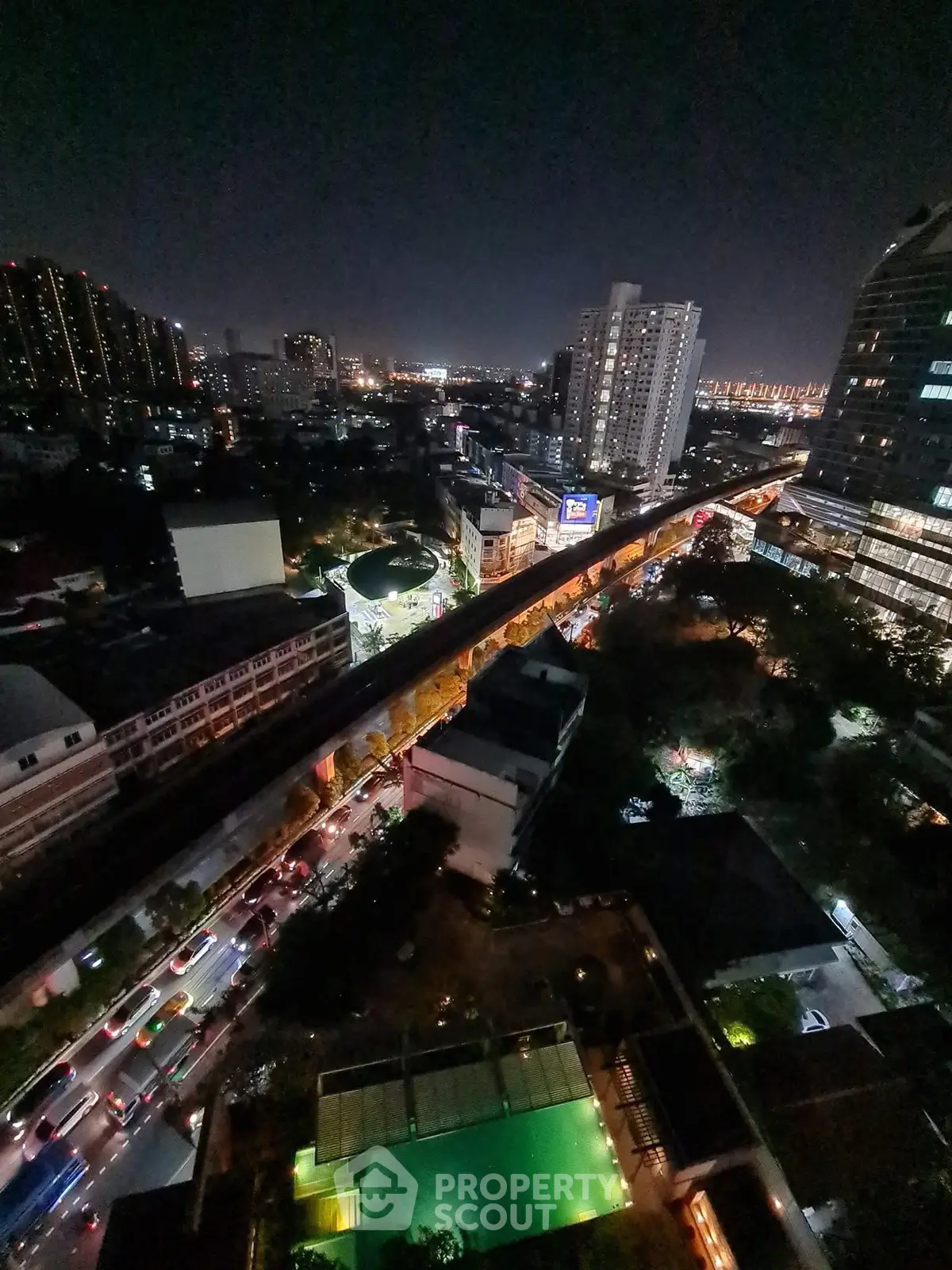 Stunning cityscape view from high-rise balcony at night with vibrant city lights.
