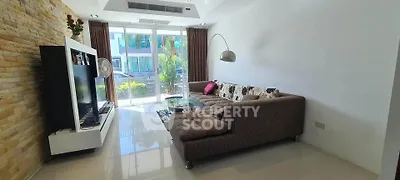 Spacious living room with modern decor and large windows offering natural light