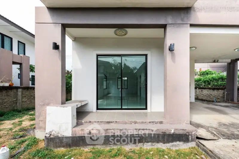 Modern house entrance with glass doors and covered porch