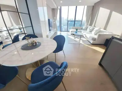Luxurious modern living room with city view, elegant furniture, and abundant natural light.