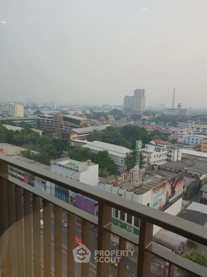 Stunning cityscape view from a high-rise balcony overlooking urban skyline and bustling streets.