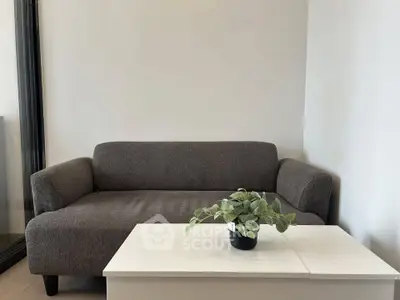 Modern living room with cozy gray sofa and stylish white coffee table.