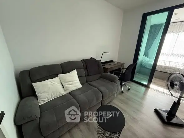 Modern living room with cozy sofa and study area in stylish apartment