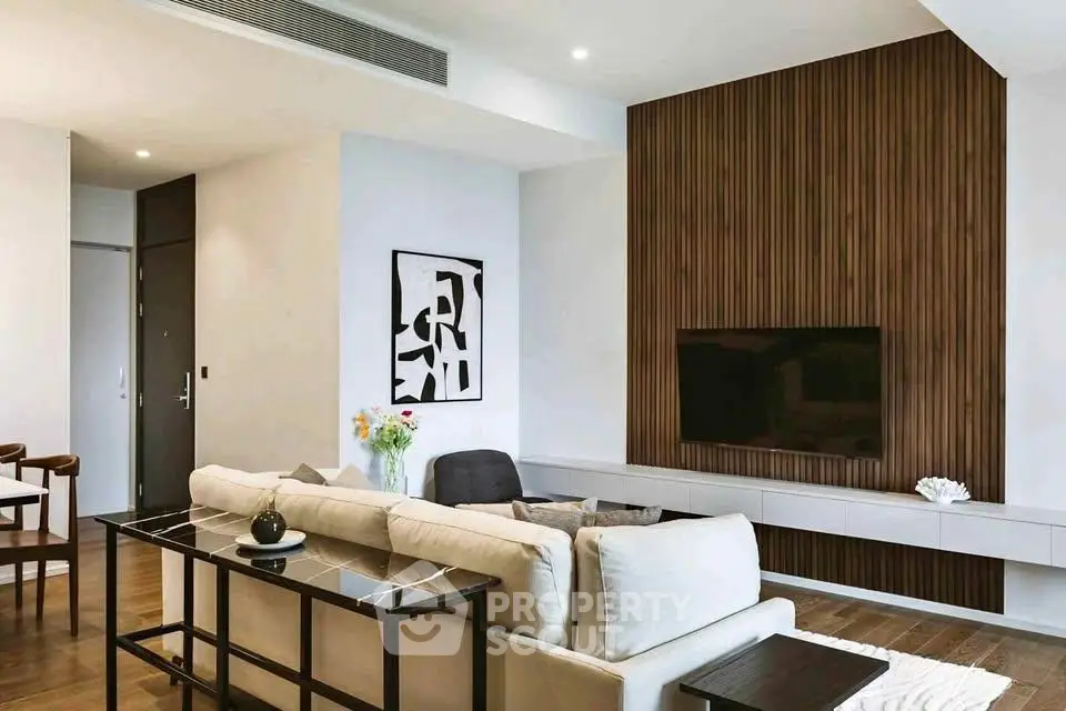 Modern living room with stylish decor and wall-mounted TV in a contemporary apartment.
