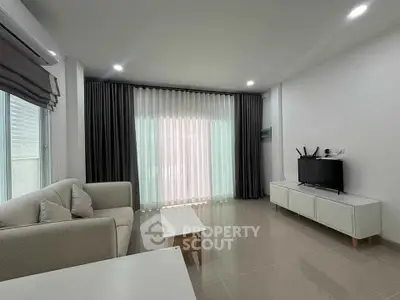 Modern living room with sleek furniture and large windows for natural light.
