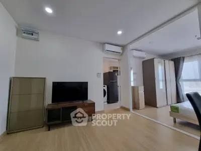 Modern living room with wooden flooring and sleek furniture in a bright apartment.