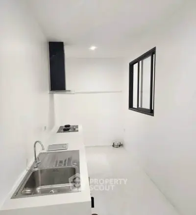 Minimalist white kitchen with sleek countertops and modern appliances