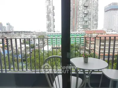 Modern balcony with city view, featuring sleek railing and cozy seating area.