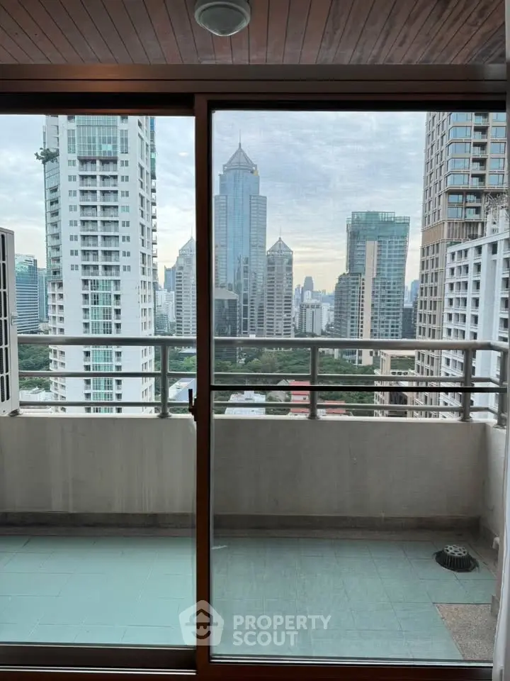 Stunning city view from high-rise balcony with glass doors