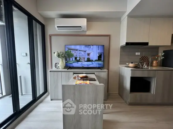 Modern living room with open kitchen, featuring sleek design and balcony access, perfect for urban living.
