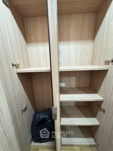 Spacious wooden storage cabinet with multiple shelves in a modern home.