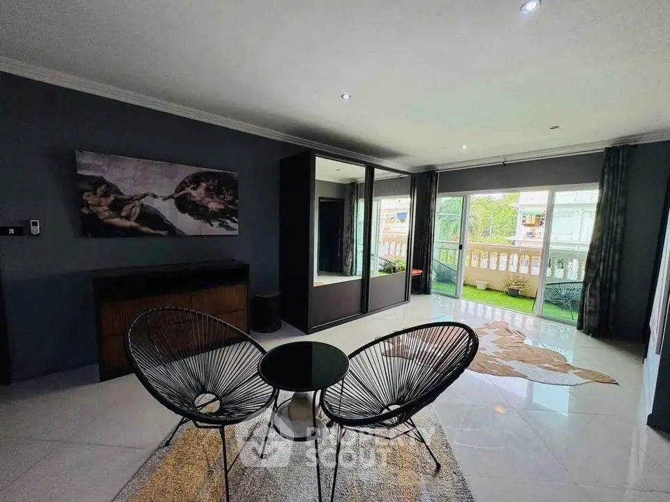 Stylish living room with modern decor and large windows offering natural light and a balcony view.