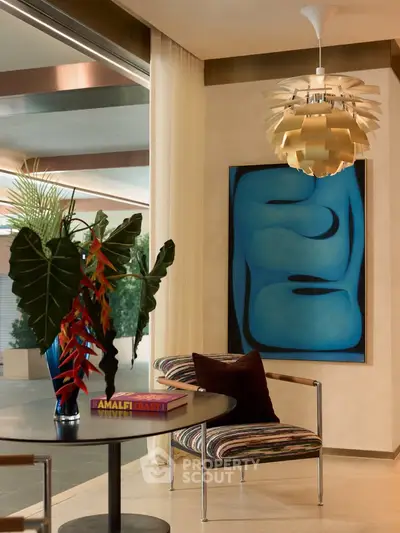 Stylish living room with modern art, designer chair, and elegant lighting.