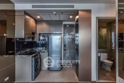 Modern kitchen with sleek appliances and marble countertops in a compact layout