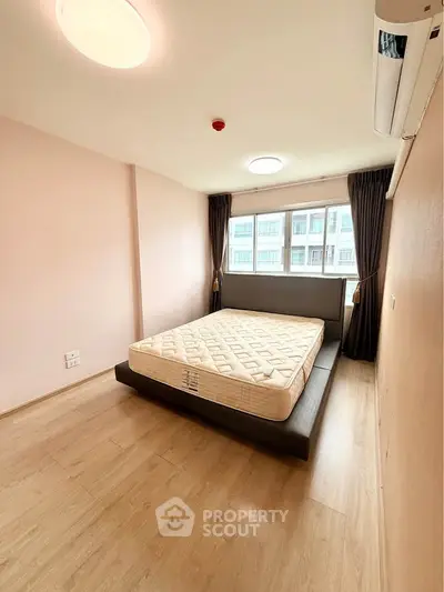Spacious bedroom with large window and modern design in a stylish apartment.