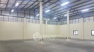 Spacious industrial warehouse with high ceilings and ample natural light.