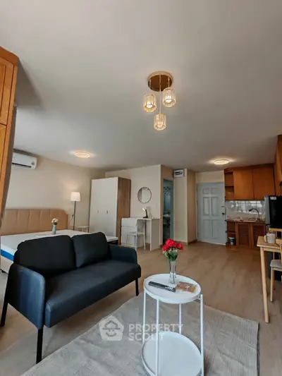 Spacious studio apartment with modern furnishings and open layout, featuring a cozy living area and stylish kitchen.