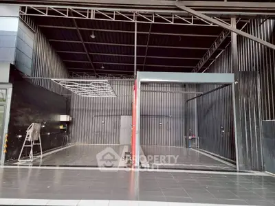 Spacious industrial-style garage with sleek black metal walls and tiled flooring.