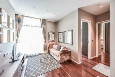 Elegant living room with hardwood floors, plush sofa, and natural light from large window.