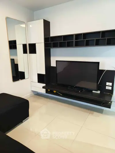 Modern living room with sleek black and white entertainment unit and wall-mounted TV.