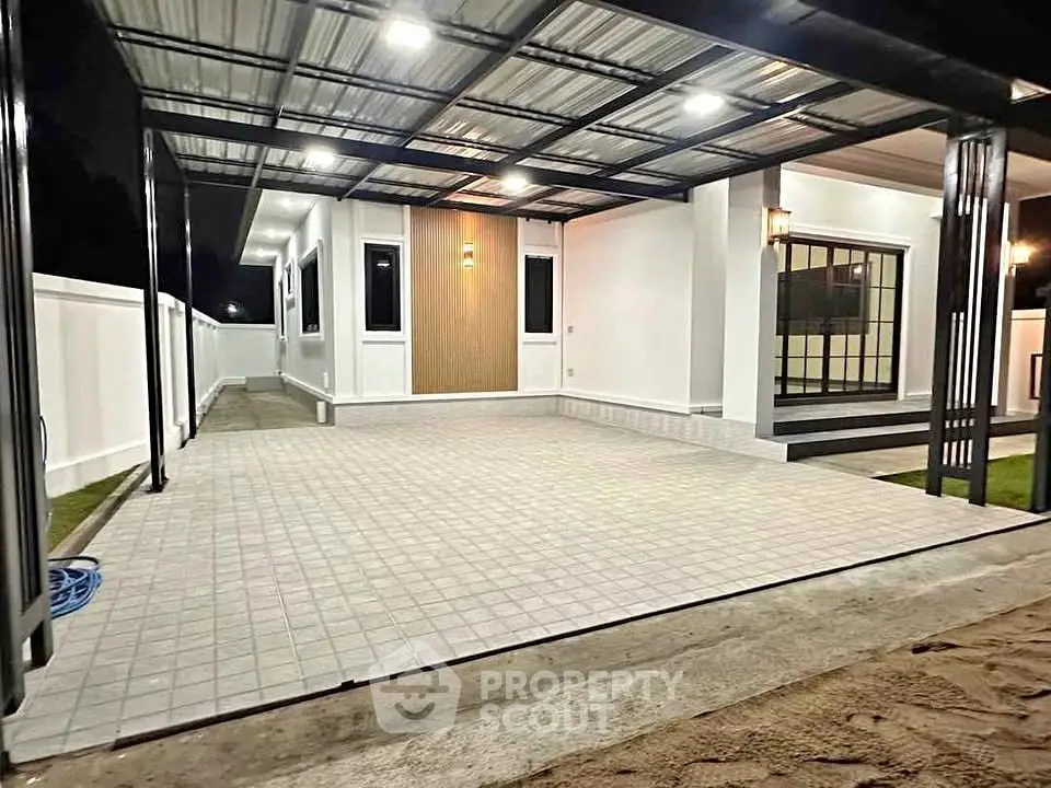 Modern house exterior with spacious tiled patio and sleek lighting