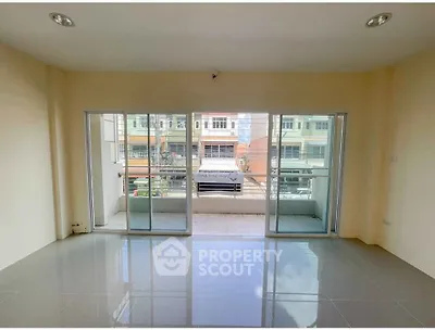 Spacious living room with large windows and balcony access in modern apartment