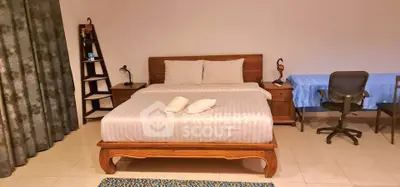 Spacious bedroom with elegant wooden bed and cozy study area, perfect for relaxation and productivity.