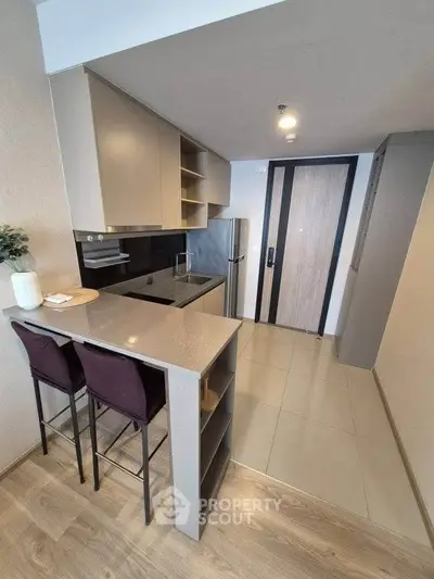 Modern kitchen with sleek cabinetry and breakfast bar in a stylish apartment.