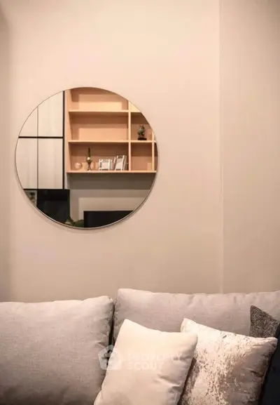 Modern living room with stylish round mirror and cozy sofa, perfect for relaxation.