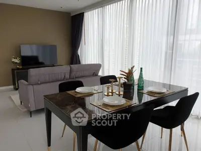 Elegant living room with modern dining area and large windows