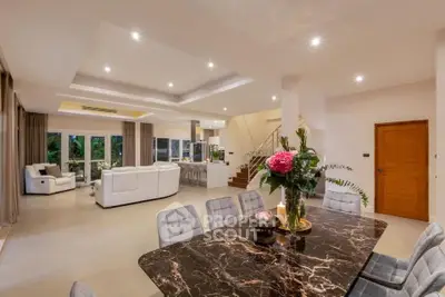 Luxurious open-plan living and dining area with elegant marble table and plush seating.