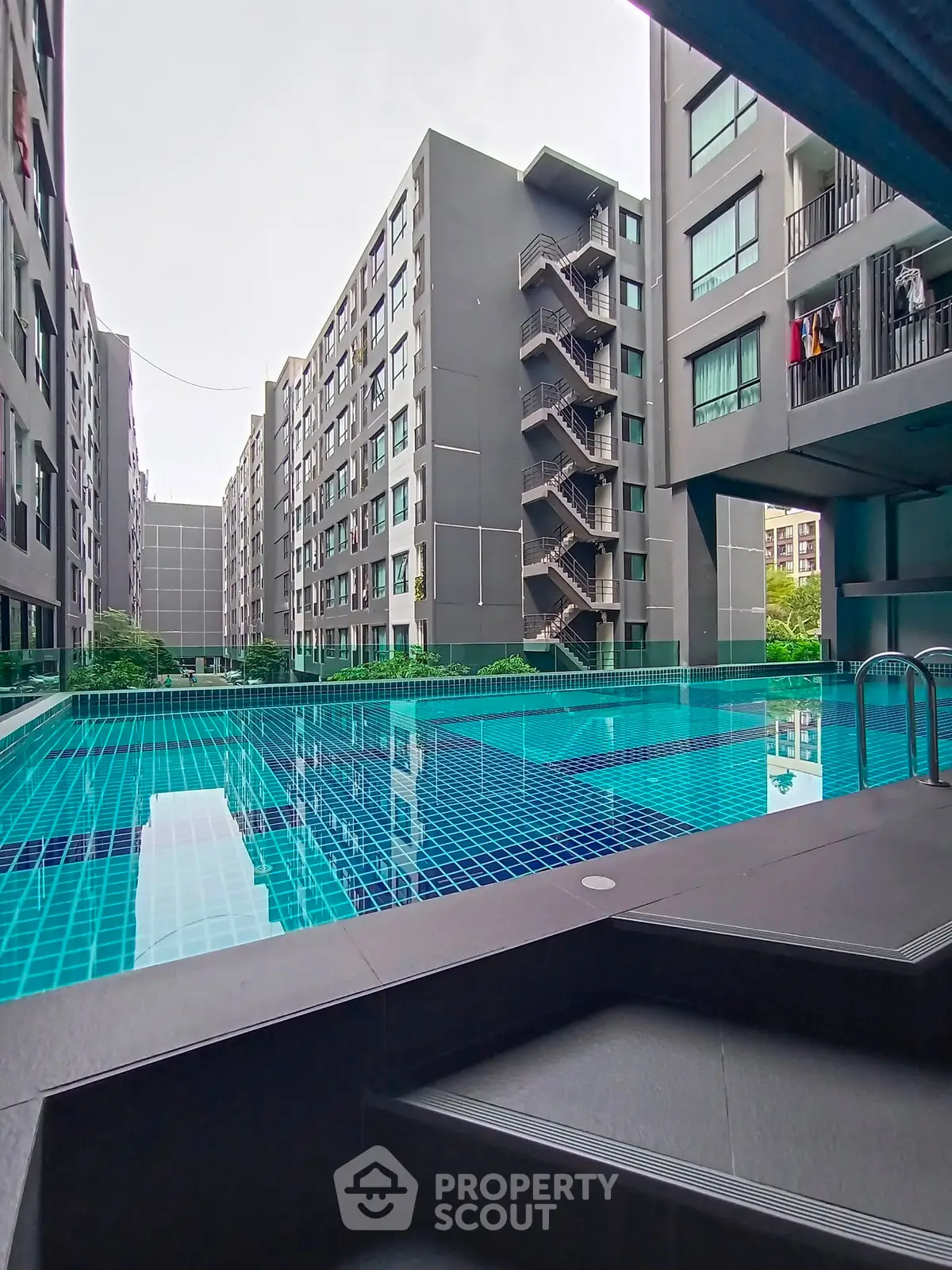 Modern apartment complex with a stunning outdoor pool and contemporary architecture.
