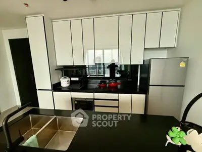 Modern kitchen with sleek cabinetry and stainless steel appliances in a stylish apartment.