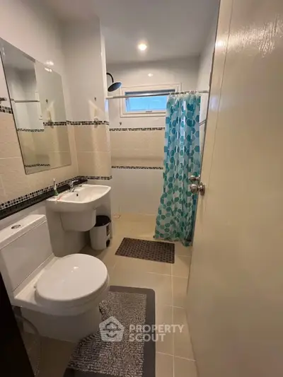 Modern bathroom with shower curtain and stylish tiles in a cozy apartment.