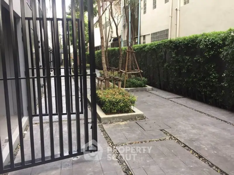 Modern apartment entrance with lush greenery and sleek design