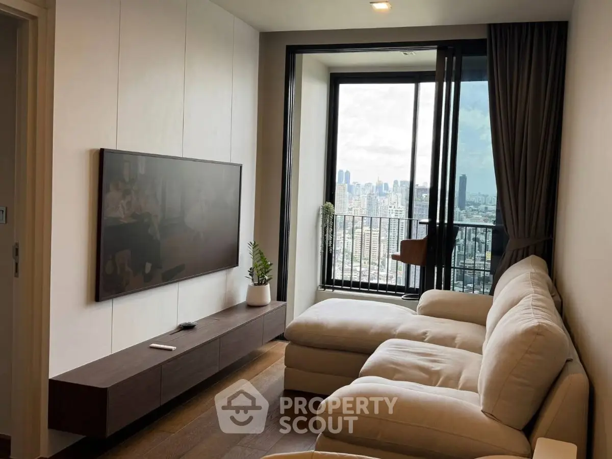 Modern living room with large window offering stunning city view, featuring a cozy sectional sofa and wall-mounted TV.