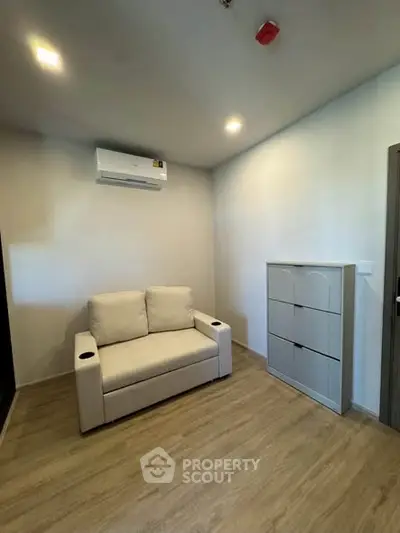Cozy living room with modern sofa and air conditioning in a minimalist apartment.