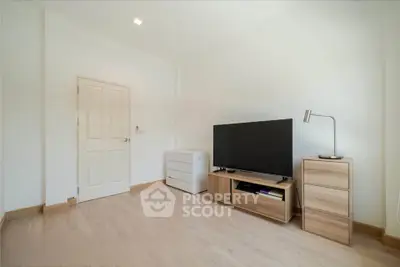 Spacious minimalist living room with modern TV setup and wooden flooring