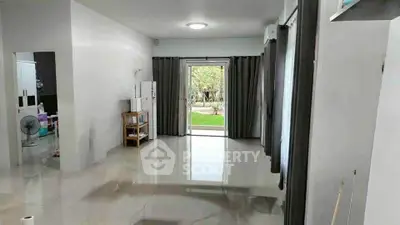 Spacious living room with garden view and modern tile flooring.