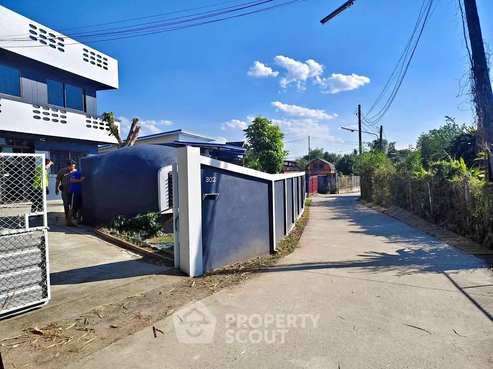 Modern residential building with sleek design and spacious driveway in a serene neighborhood.