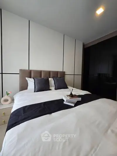 Modern bedroom with stylish decor and cozy bedding in a contemporary apartment.