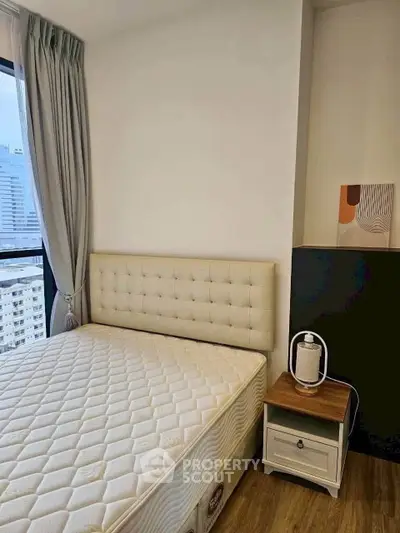 Cozy bedroom with city view, featuring a plush bed and modern decor, perfect for urban living.