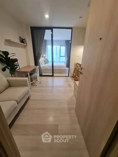 Modern apartment interior with cozy living area and bedroom view